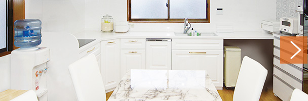 ツヤ感が美しい白い框扉のL型キッチン